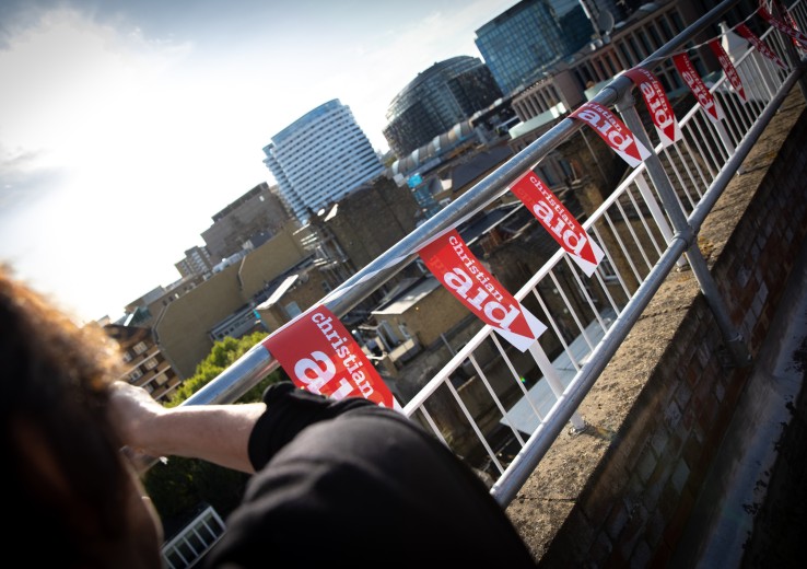Supporter hanging Christian Aid bunting